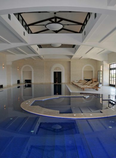 View of the indoor pool with French windows with fuseruoli in the background